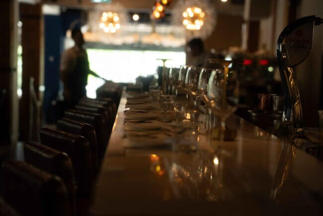Elegant bar interior at Blu Ristorante on King Street Toronto, featuring dim lighting, wine glasses, and modern Italian ambiance.