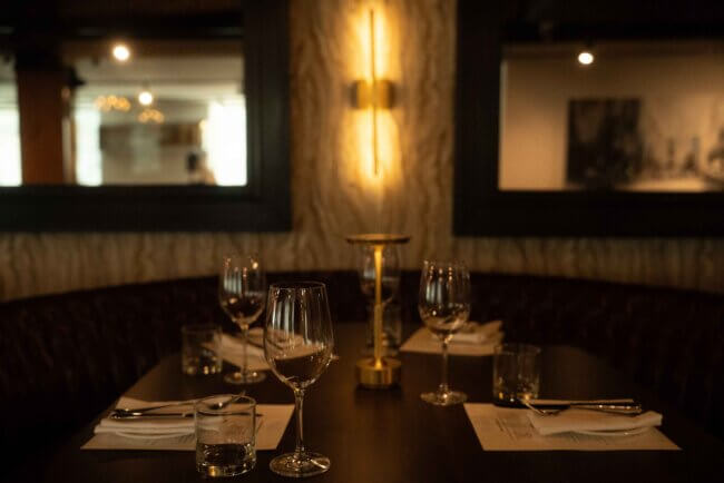 Elegant candlelit dining table set with glassware and napkins in a cozy upscale restaurant interior