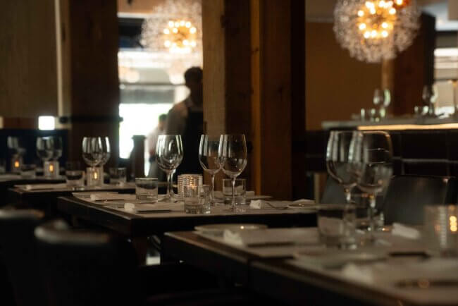Elegant outdoor dining area at a fine-dining restaurant, with a table set under evening lights.