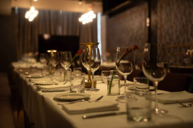 Elegant table setting at a premium restaurant, complete with wine glasses and linen napkins.