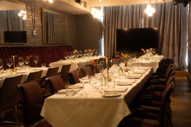 Formal dining setup with multiple tables set for a large gathering.