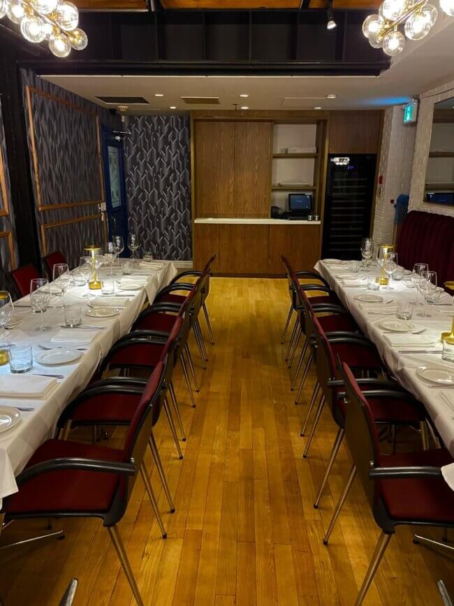 Dining area featuring a long table setup in a contemporary restaurant.