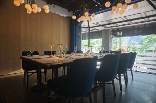 Stylish restaurant table arrangement with warm lighting and blue seating.