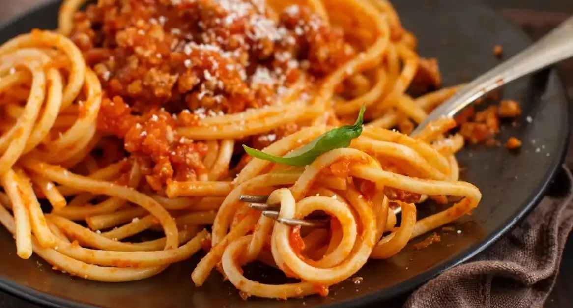Classic Italian spaghetti Bolognese served with a rich meat sauce and garnished with Parmesan cheese, an ideal pairing for hearty pasta lovers.