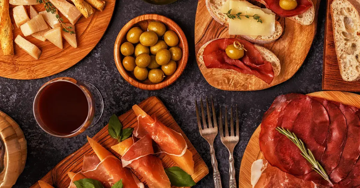 Traditional Italian antipasto platter with cured meats, Parmesan cheese, olives, and bread, representing authentic Italian flavors.