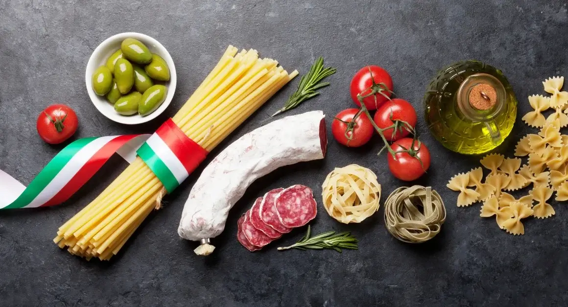 Traditional Italian food ingredients including pasta, olives, salami, tomatoes, and olive oil representing authentic Italian culinary culture.