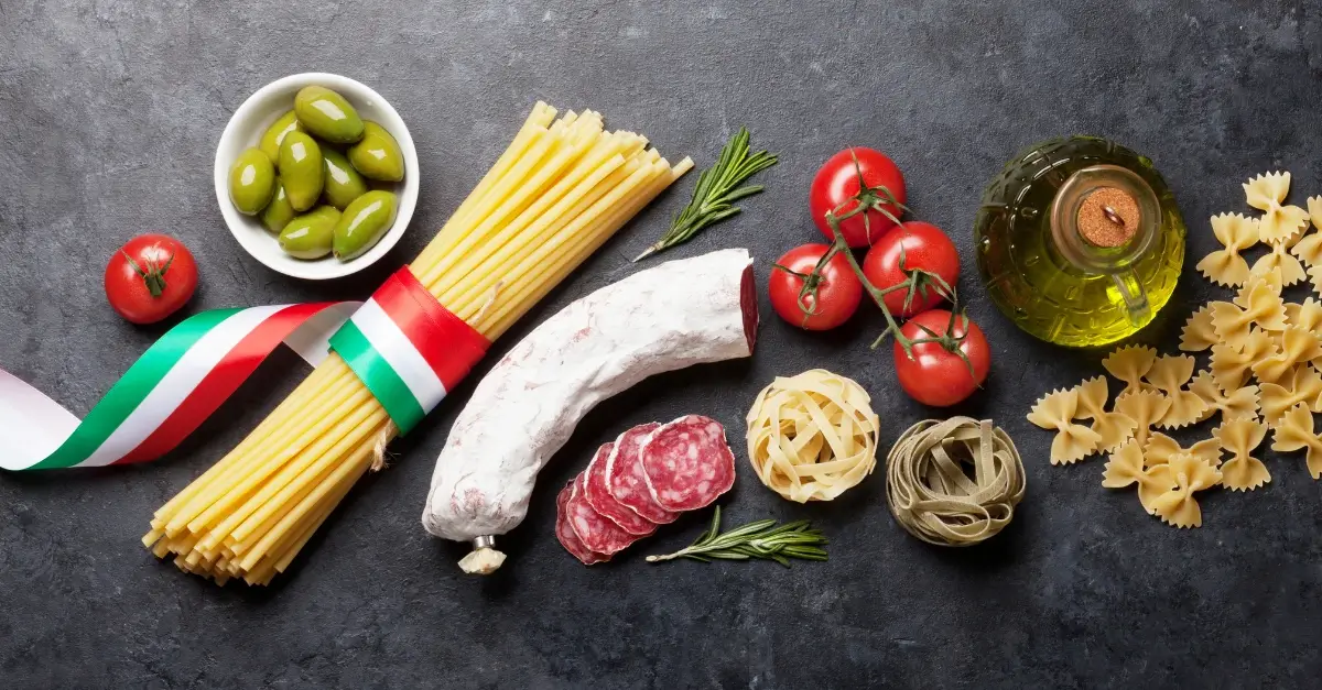 Traditional Italian food ingredients including pasta, olives, salami, tomatoes, and olive oil representing authentic Italian culinary culture.