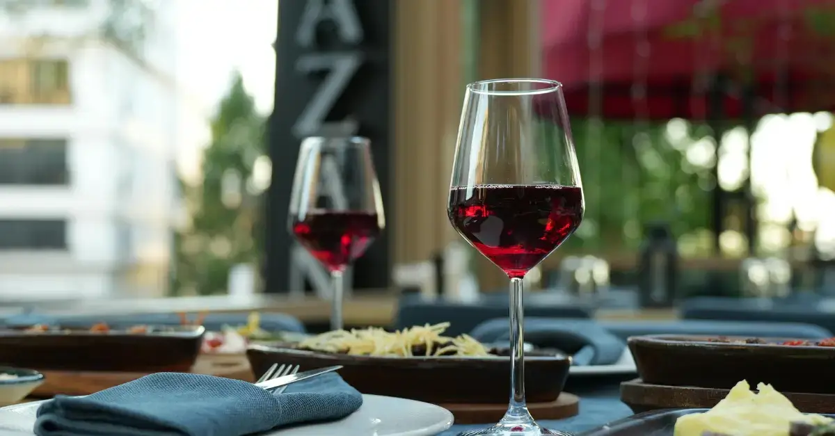 Two glasses of red wine on a dining table at an Italian restaurant, representing classic wine pairings with Italian cuisine.
